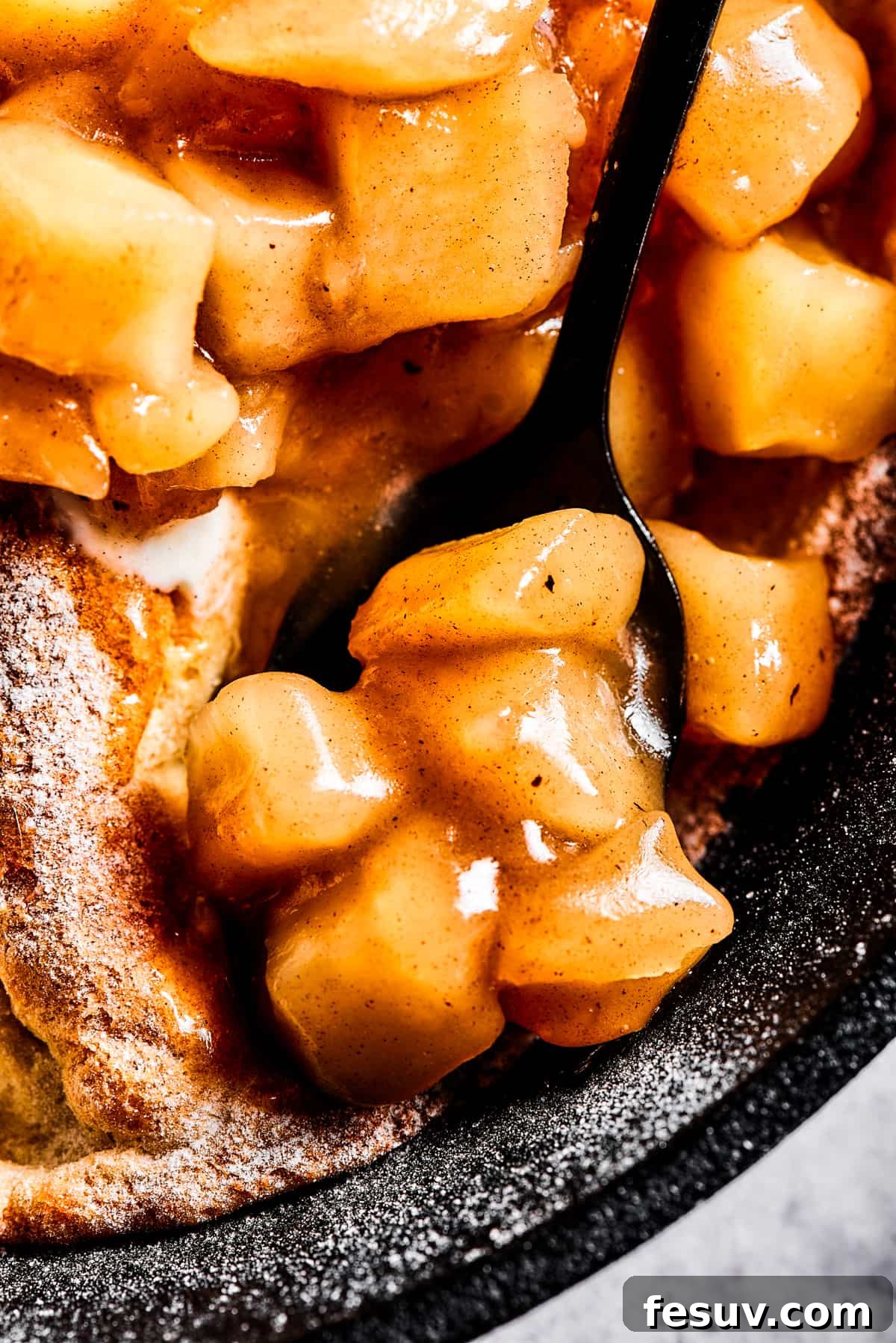 close up photo of a spoon with apple pie filling.