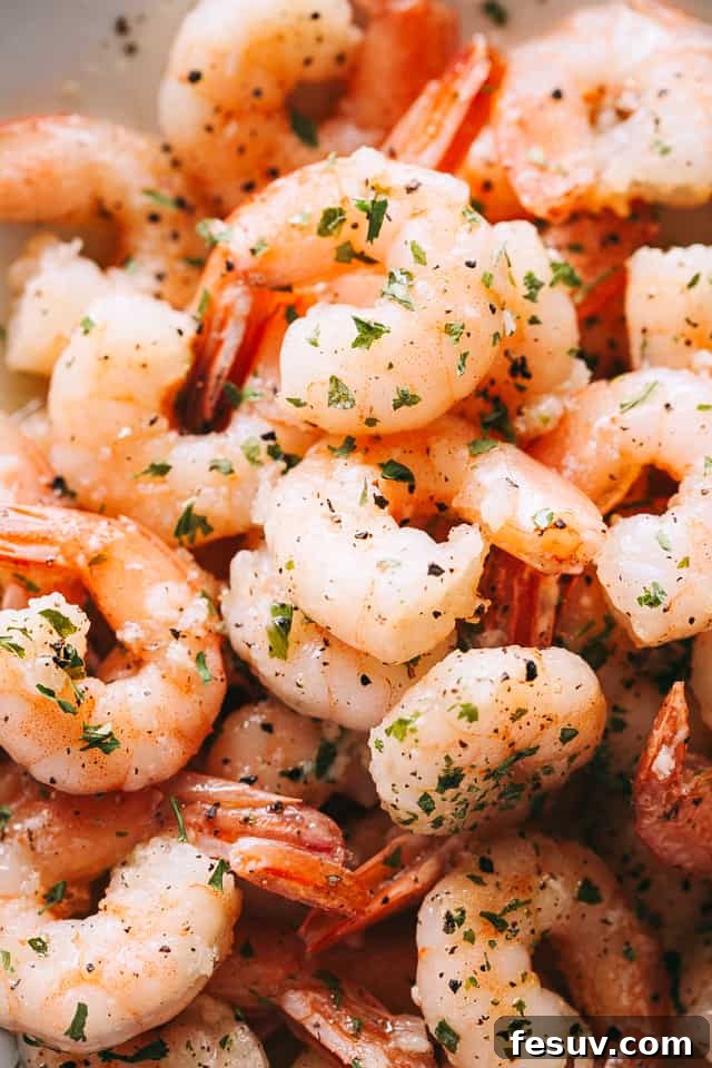 An inviting up-close shot of perfectly cooked shrimp, glistening in a white skillet, ready to be added to the fresh salad.