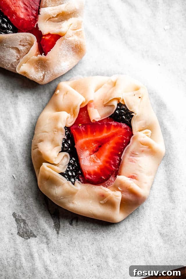 pie dough rounds filled with fresh berries, ready to be folded
