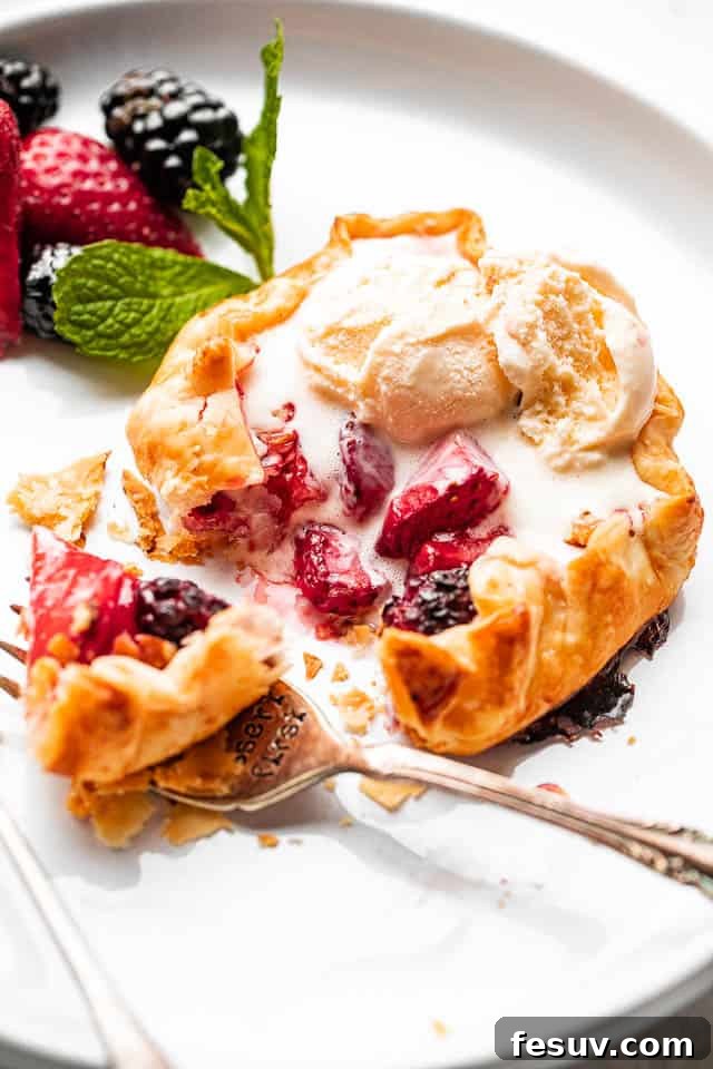 side view of berries stuffed in a mini galette and topped with ice cream, ready to be enjoyed