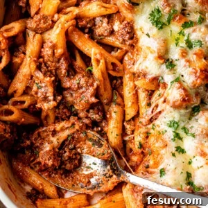 penne pasta casserole with ground beef in a white baking dish