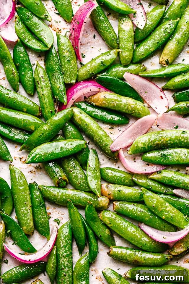 top view of roasted sugar snap peas and sliced red onions