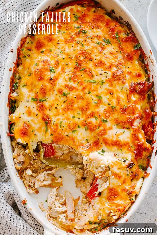 top view of chicken fajita casserole in an oval baking dish topped with melted cheese