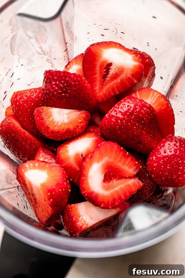 Pink Lemonade Berry Sangria 3 Fresh, vibrant strawberries ready to be blended for the homemade strawberry puree, essential for the best Strawberry Lemonade Sangria.