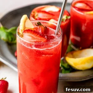 Pink Lemonade Berry Sangria 7 strawberry lemonade sangria in a tall glass and topped with strawberries and lemons