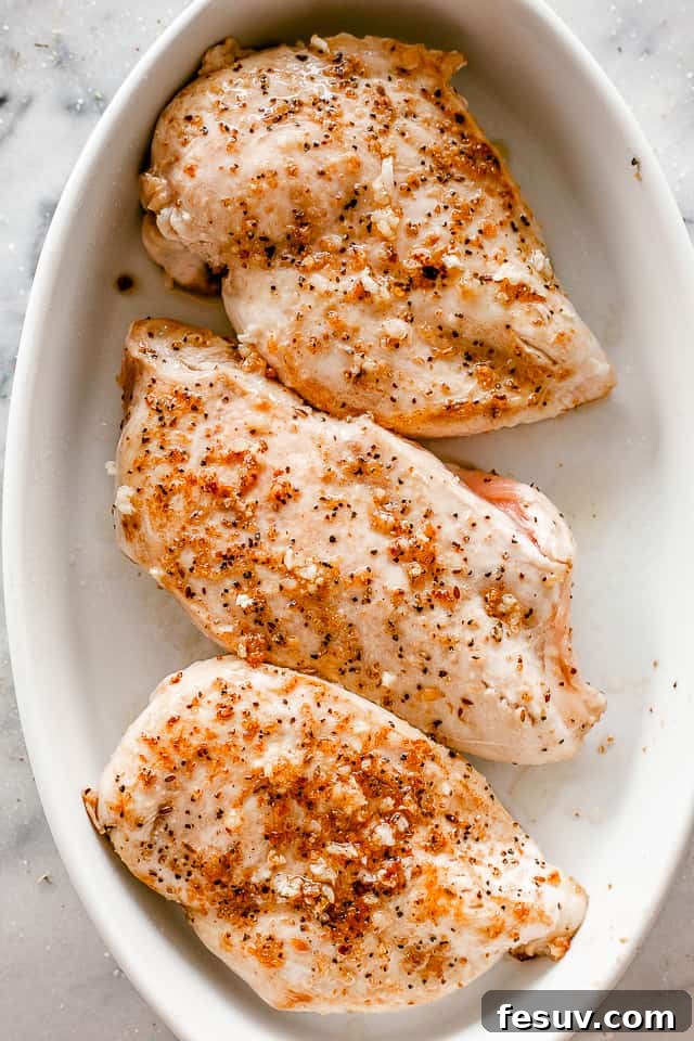 Zesty Caesar Baked Chicken 3 top view of seasoned chicken breasts in a white oval baking dish