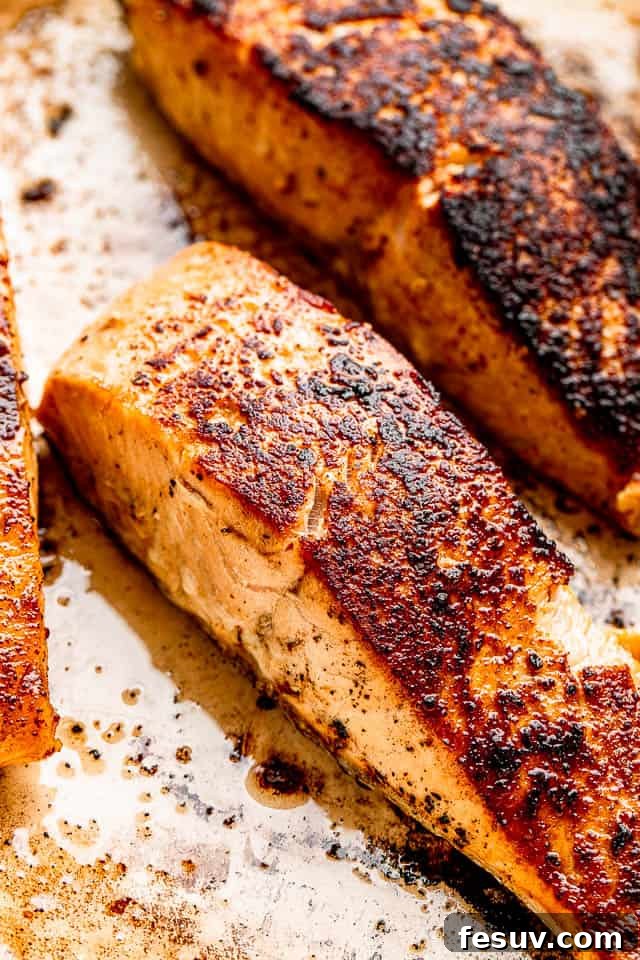 Close-up top view of perfectly seared salmon fillets, showcasing their crispy skin and rich color, ready to be sauced.