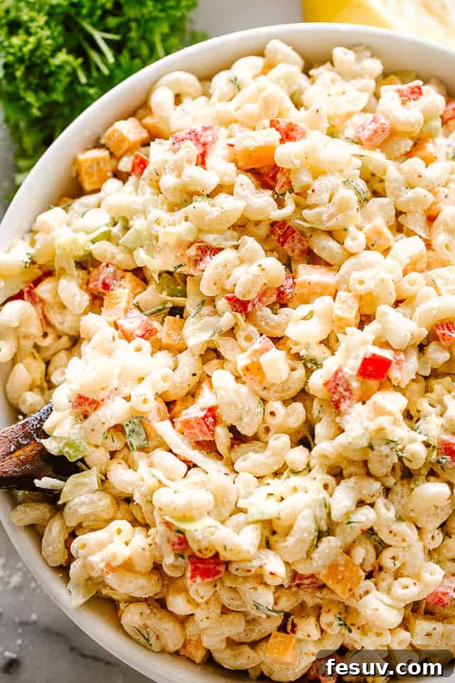 Large bowl of macaroni salad with a serving spoon.