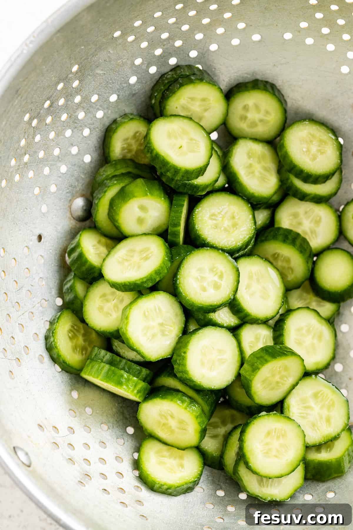 Straining the rinsed cucumbers.