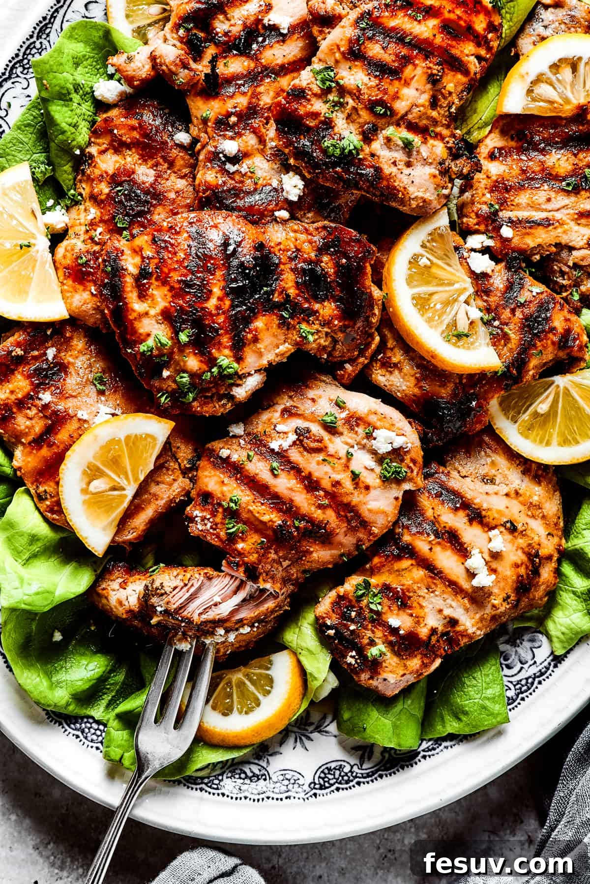 Demonstrating the tenderness of yogurt marinated chicken. A fork pulling apart a piece of grilled yogurt-marinated chicken, showcasing its incredible tenderness and juiciness.