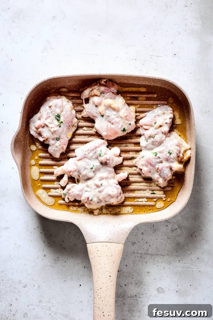 Grilling yogurt marinated chicken to perfection. Grilled chicken thighs cooking on a hot grill pan, showing perfect char marks and sizzling gently.