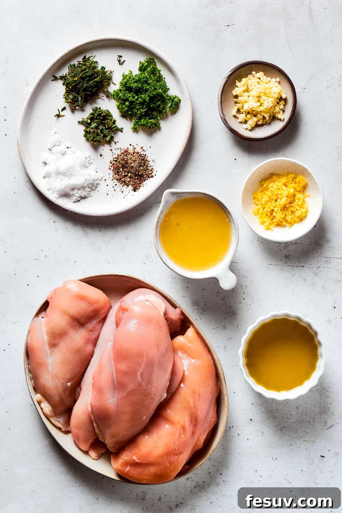 Fresh, flavorful Lemon Chicken is incredibly easy to make, and totally mouthwatering, too! Black pepper, garlic, fresh herbs, and lemon. Yum! From top: Seasonings, minced garlic, fresh lemon juice, raw chicken breasts, and olive oil laid out as ingredients.