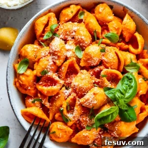 Pasta in a bowl, garnished with basil.
