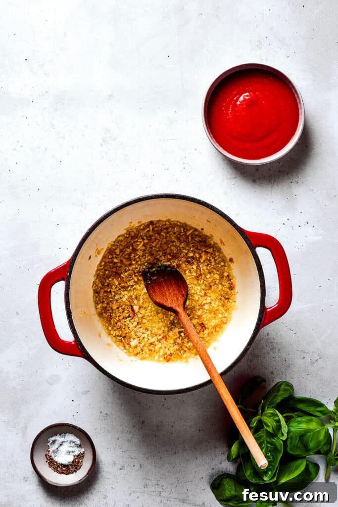 Garlic and shallots gently cooking in a saucepan, releasing their aromatic flavors.