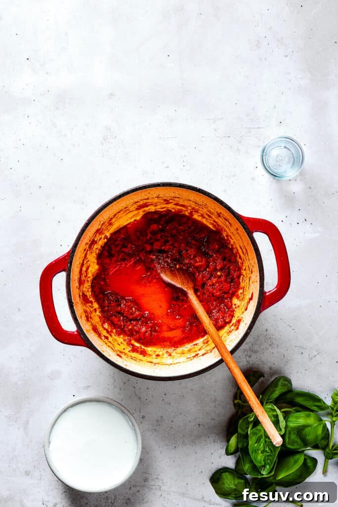 Adding a generous sprinkle of red pepper flakes and other seasonings to the simmering sauce.