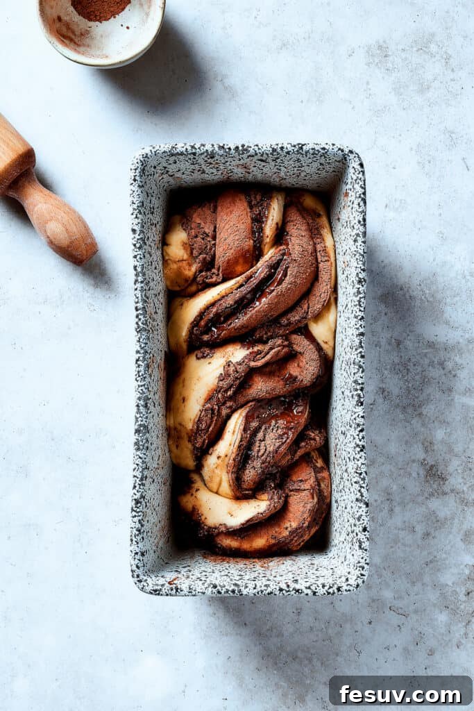 Twisted lengths of chocolate-filled dough placed in a loaf pan.