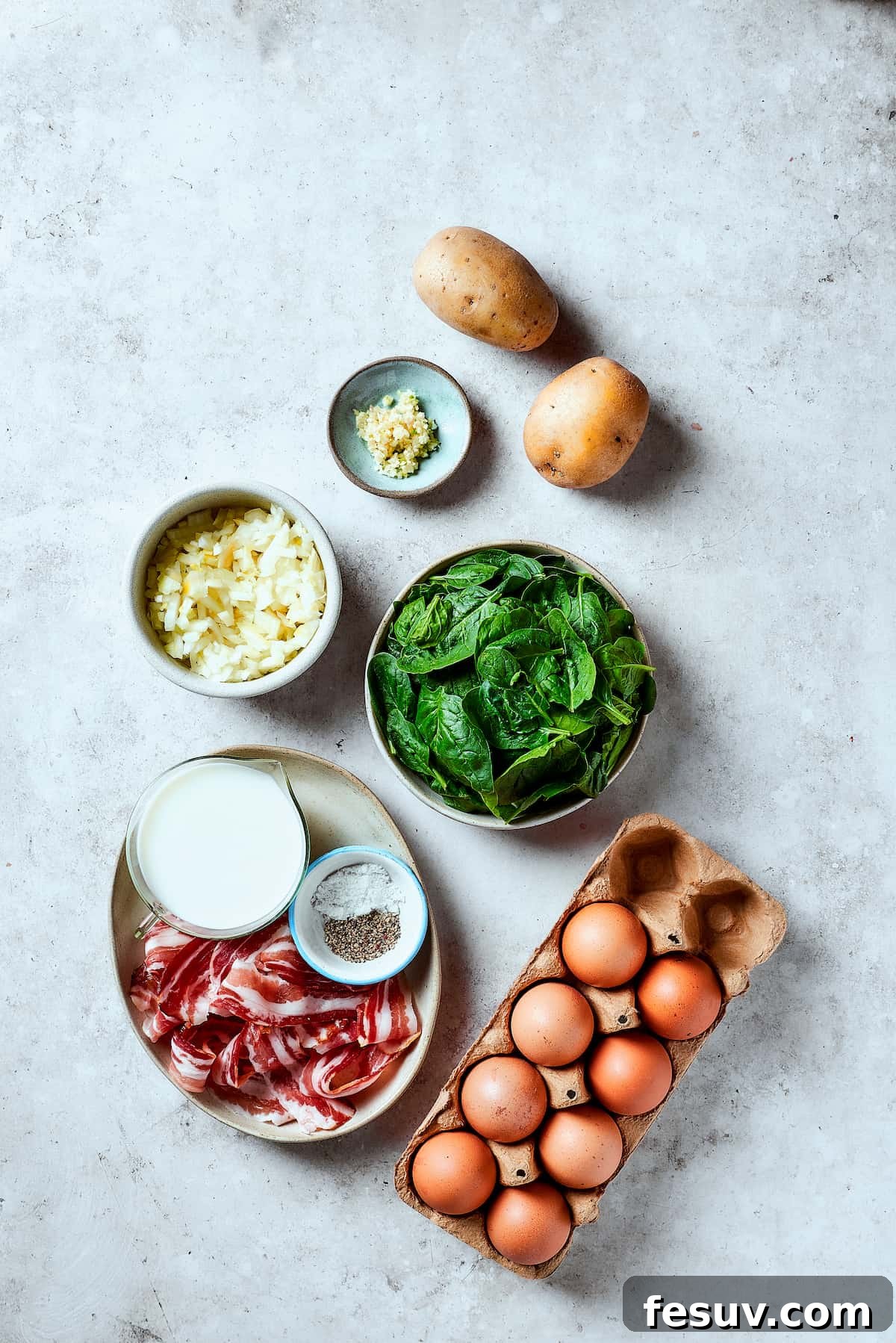 Spinach, Bacon, and Potato Frittata is a healthy, farmhouse-style dinner that's easy to make, and loaded with rich flavor. Perfect easy meal! From top: Potatoes, spinach, eggs, bacon, salt and pepper, milk, onion, garlic.
