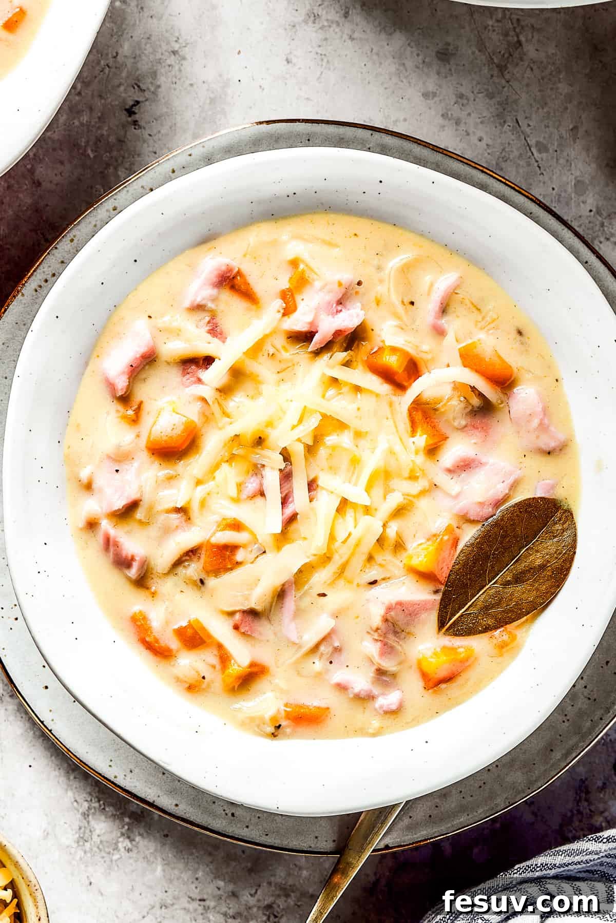 This Creamy Reuben Soup takes corned beef, sauerkraut, and Swiss to a whole new level! It's a comfy, cozy masterpiece in a bowl. A bowl of creamy soup with a bay leaf in it.