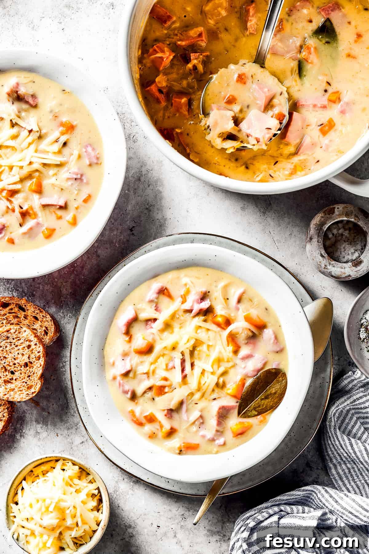 This Creamy Reuben Soup takes corned beef, sauerkraut, and Swiss to a whole new level! It's a comfy, cozy masterpiece in a bowl. A pot of Reuben soup with two bowls of the soup next to it.