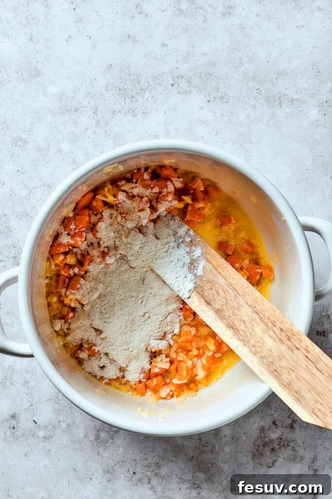 This Creamy Reuben Soup takes corned beef, sauerkraut, and Swiss to a whole new level! It's a comfy, cozy masterpiece in a bowl. Adding flour to cooked veggies in a Dutch oven.
