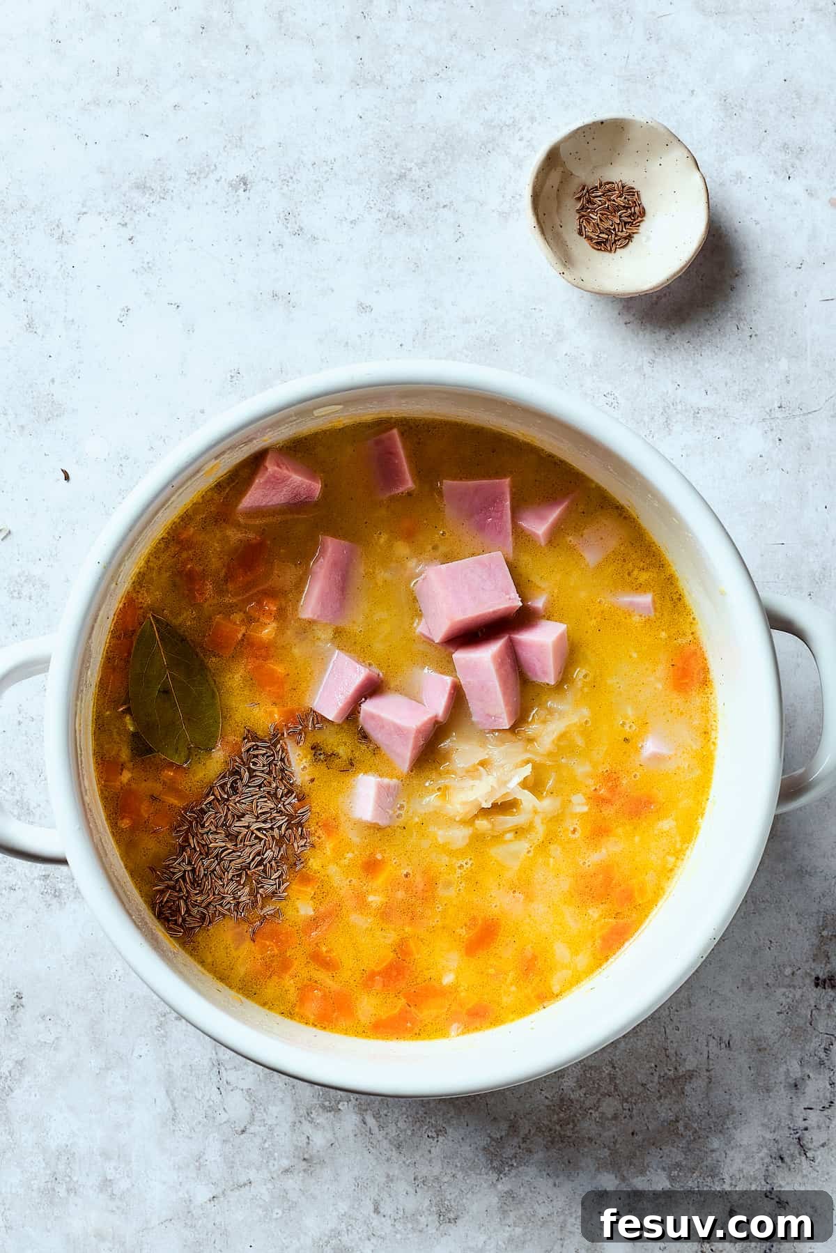 This Creamy Reuben Soup takes corned beef, sauerkraut, and Swiss to a whole new level! It's a comfy, cozy masterpiece in a bowl. Reuben soup base without dairy and croutons, cooking in a pot.