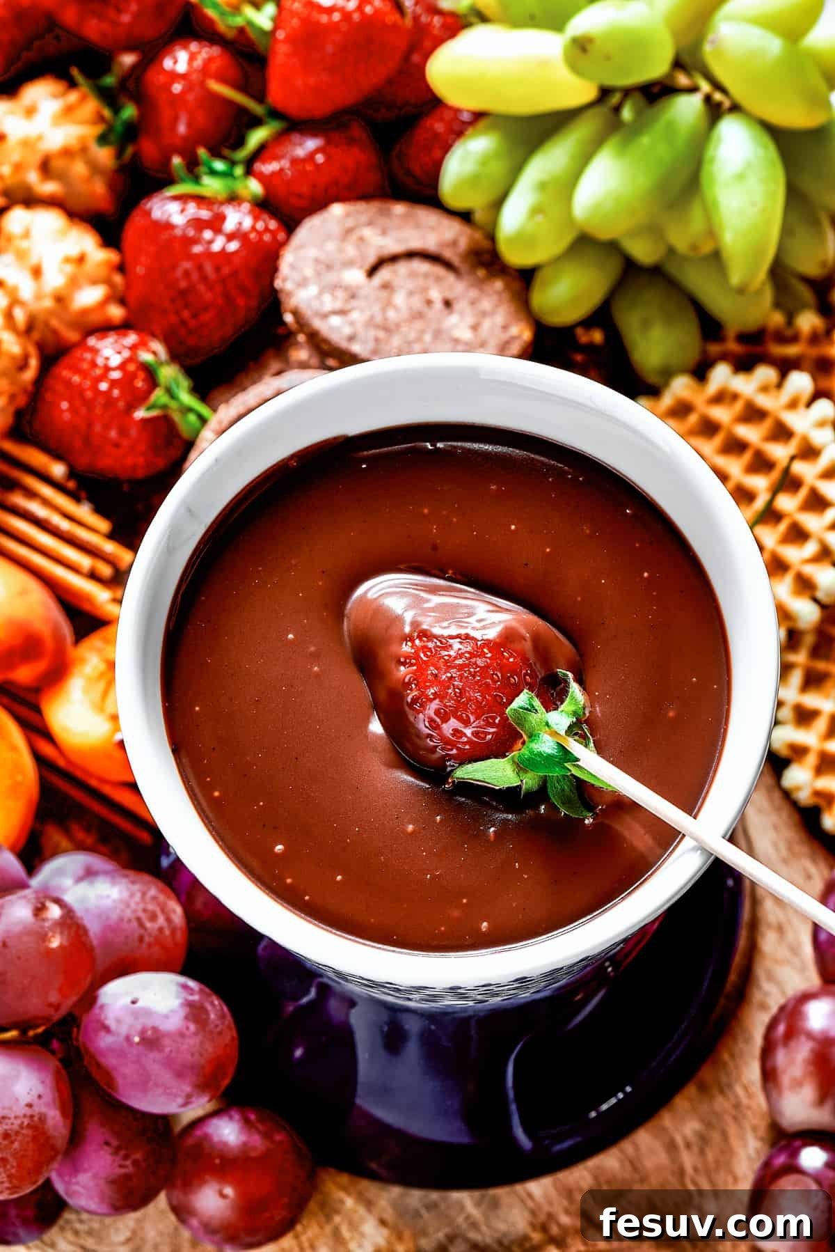 Velvet Chocolate Fondue 2 Dipping a strawberry in chocolate fondue.