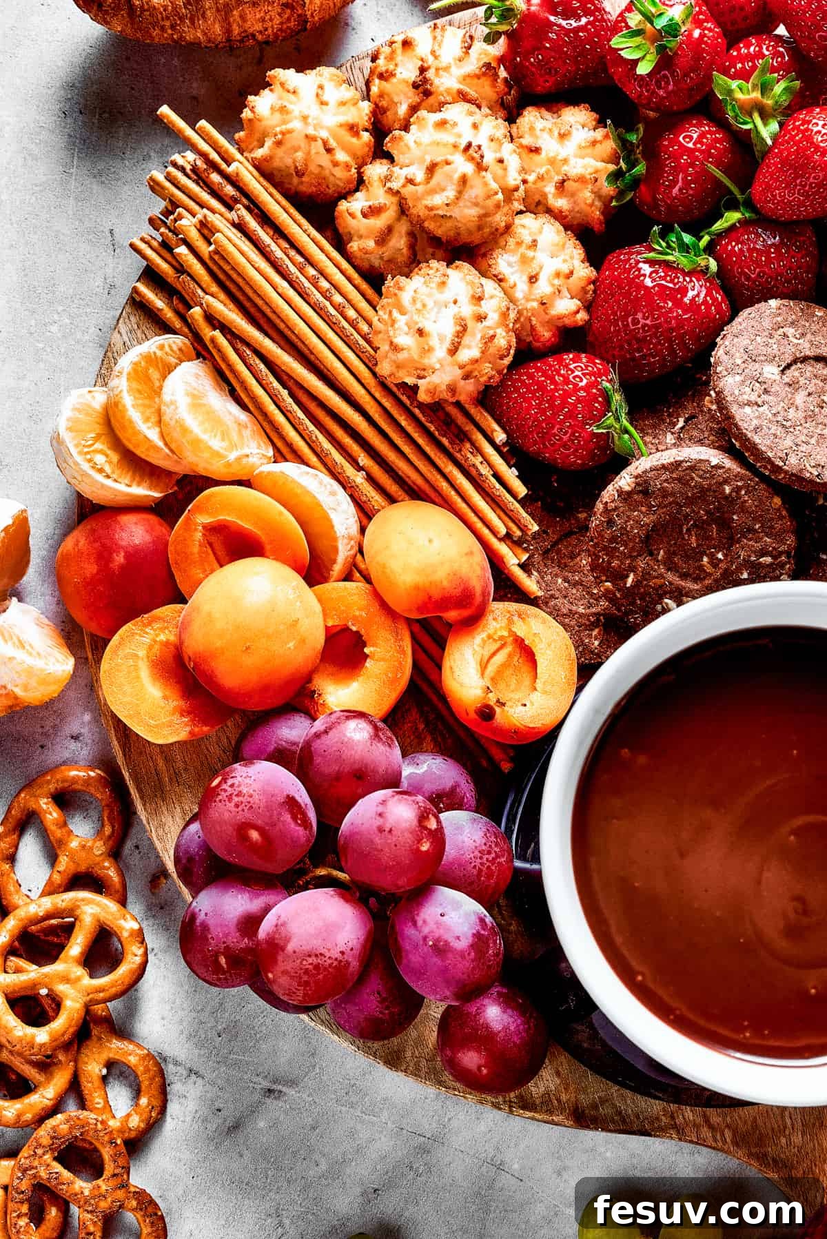 Velvet Chocolate Fondue 5 A wooden charcuterie board with sweet and savory dippers and chocolate sauce.