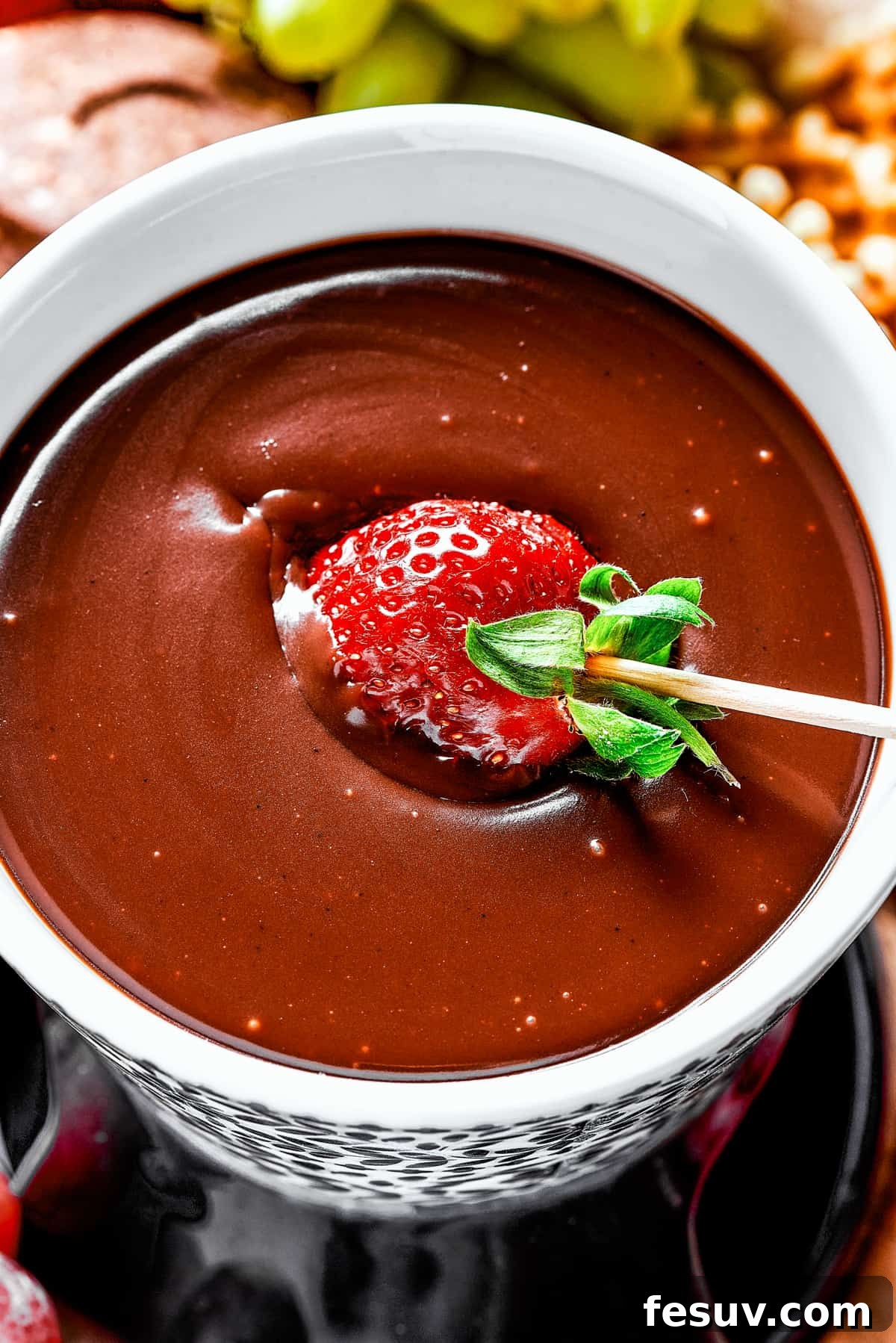 Velvet Chocolate Fondue 9 Dipping a strawberry in chocolate fondue.