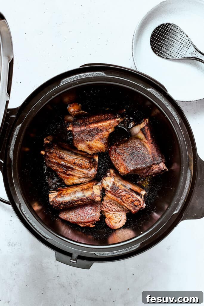 Instant Pot Short Ribs with balsamic sauce are easy to make and so good. Using the Instant Pot gives you irresistibly tender short ribs. Perfectly seared short ribs, golden brown and caramelized, resting in an Instant Pot after browning.