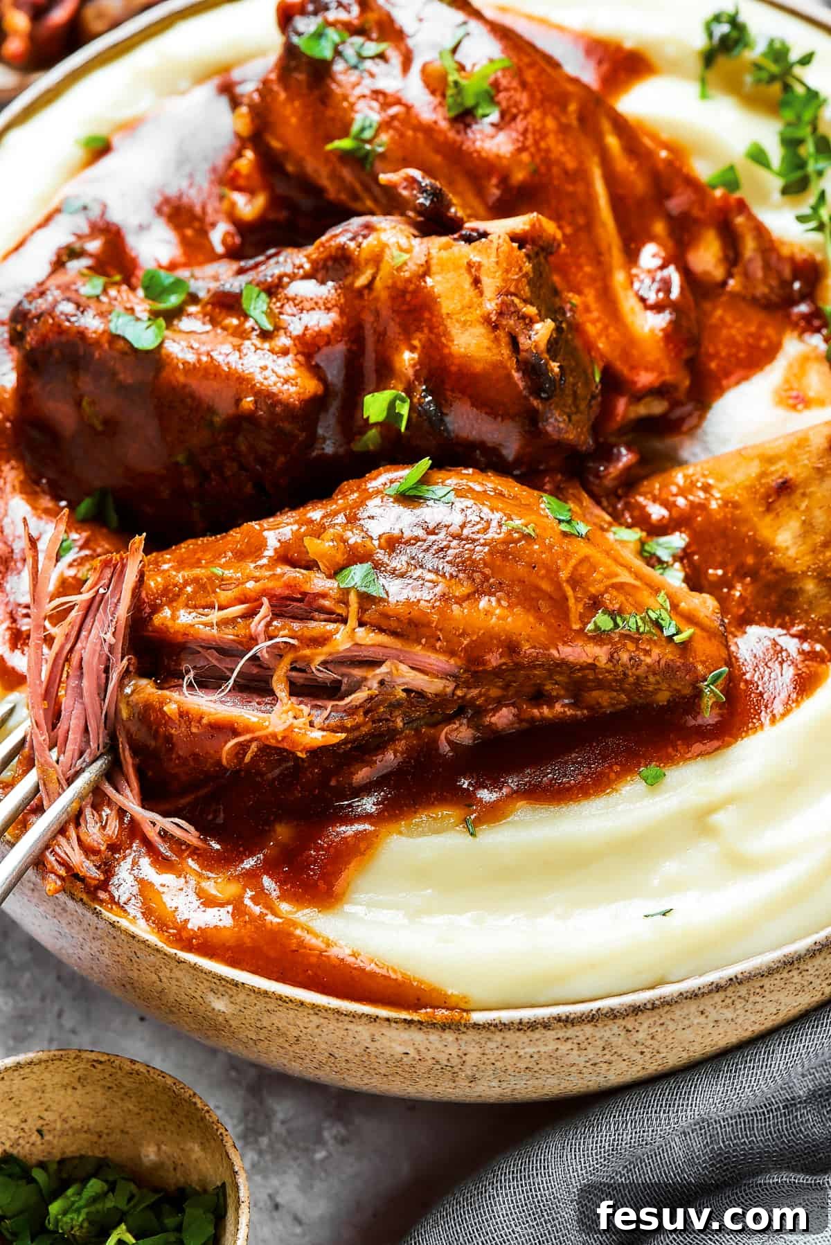 Instant Pot Short Ribs with balsamic sauce are easy to make and so good. Using the Instant Pot gives you irresistibly tender short ribs. A fork gently pulling apart the succulent meat of a short rib, perfectly showcasing its extreme tenderness and juiciness.