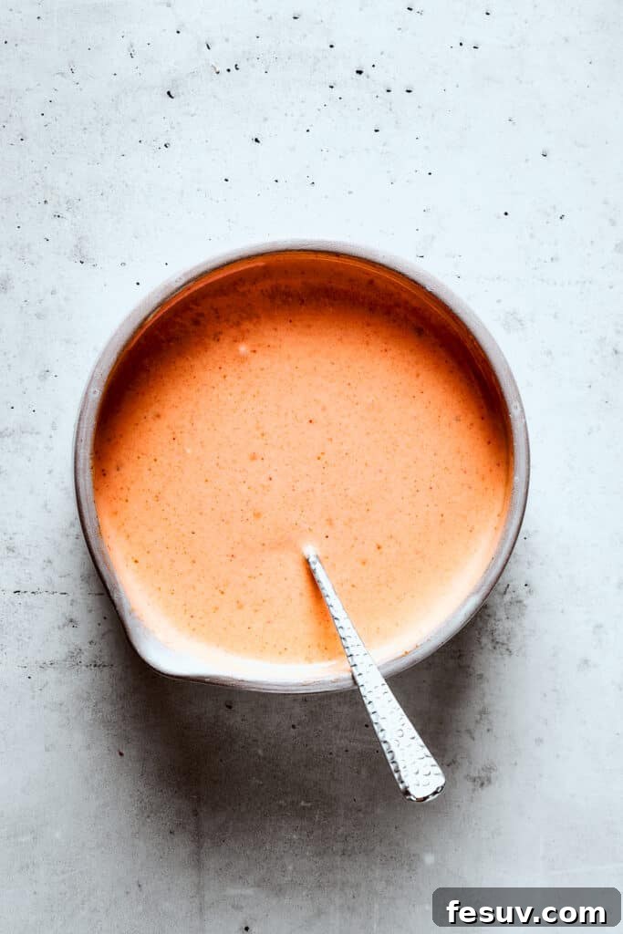 Mixing the yum yum sauce with a spoon.
