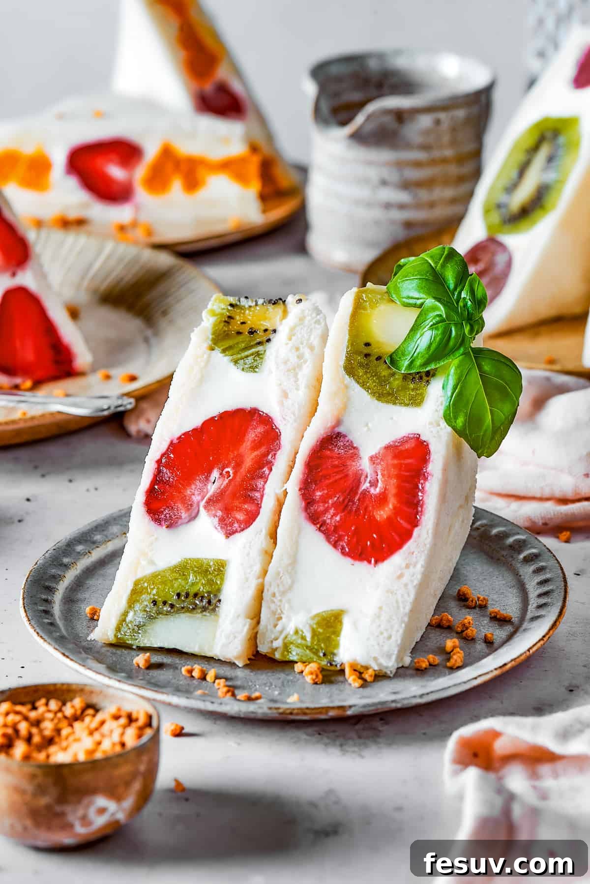 A sliced fruit sando featuring kiwi and strawberry arranged on a plate.