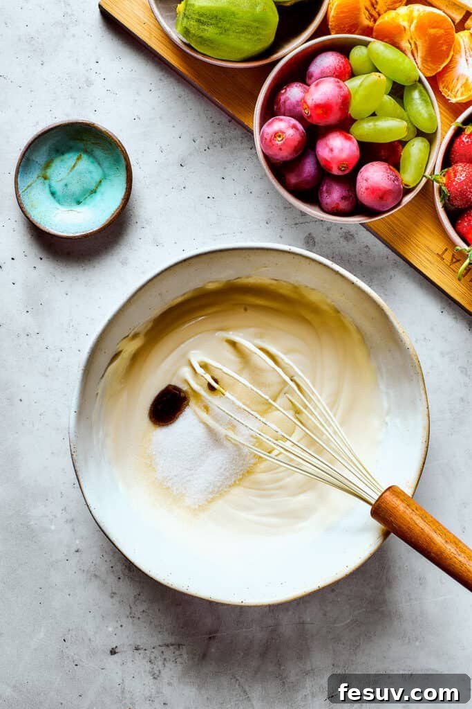 Whipping heavy cream with sugar and vanilla in a mixing bowl.