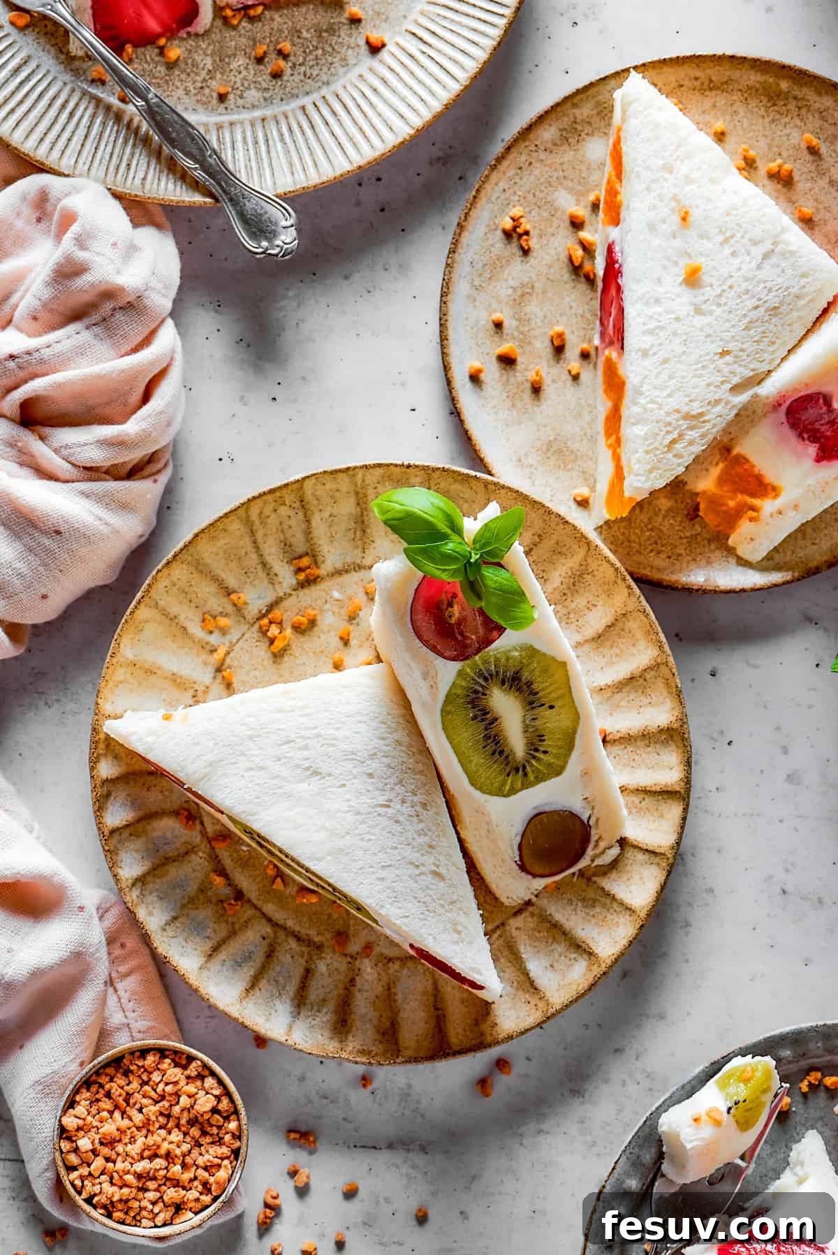 Fruit sandwiches on small, decorative plates, ready to be served.