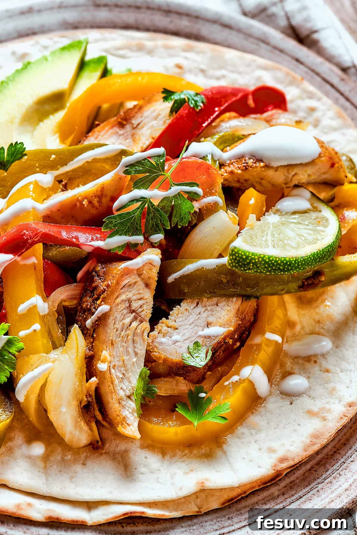 A serving of slow cooker chicken fajitas artfully topped with a swirl of sour cream, ready to enjoy.