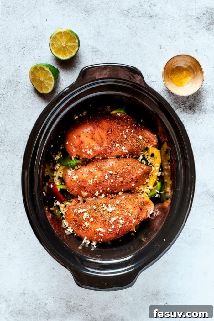 Fajita chicken simmering with colorful peppers and onions in a slow cooker.