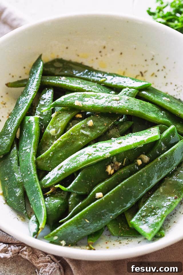 Romano Beans cooked in Garlic Butter are a delicious blend of healthy and tasty, easily prepared in no time! Blanched Italian Flat Beans served in a large white bowl, vibrant and ready for seasoning.