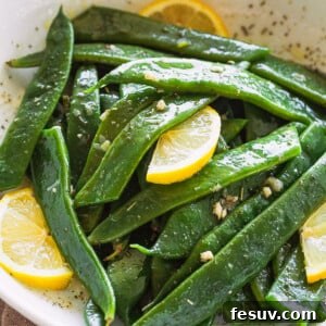Garlic Butter Romano Beans served with lemon slices.