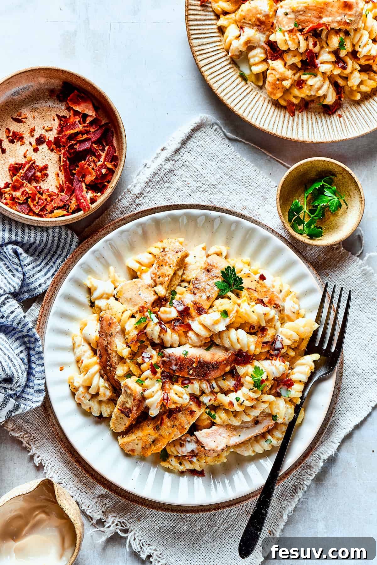 Serving Up Comfort: Delicious Chicken Bacon Ranch Pasta! Overhead shot of two dinner plates filled with creamy chicken bacon ranch pasta, ready to be enjoyed.