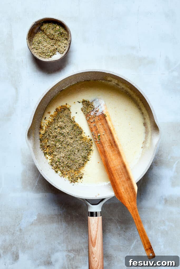The Heart of the Dish: Developing the Rich Ranch Sauce! The creamy half-and-half sauce thickening in a skillet, infused with ranch seasoning.