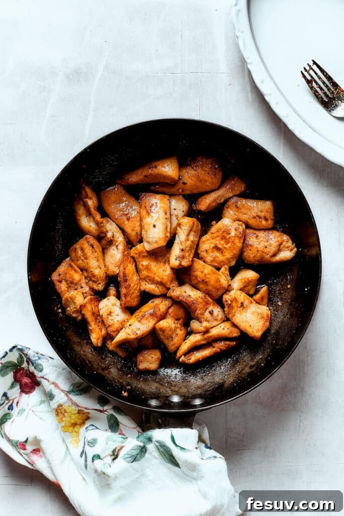 Perfectly browned chicken strips in the skillet. Chicken strips browning in a hot skillet, showing a golden crust.