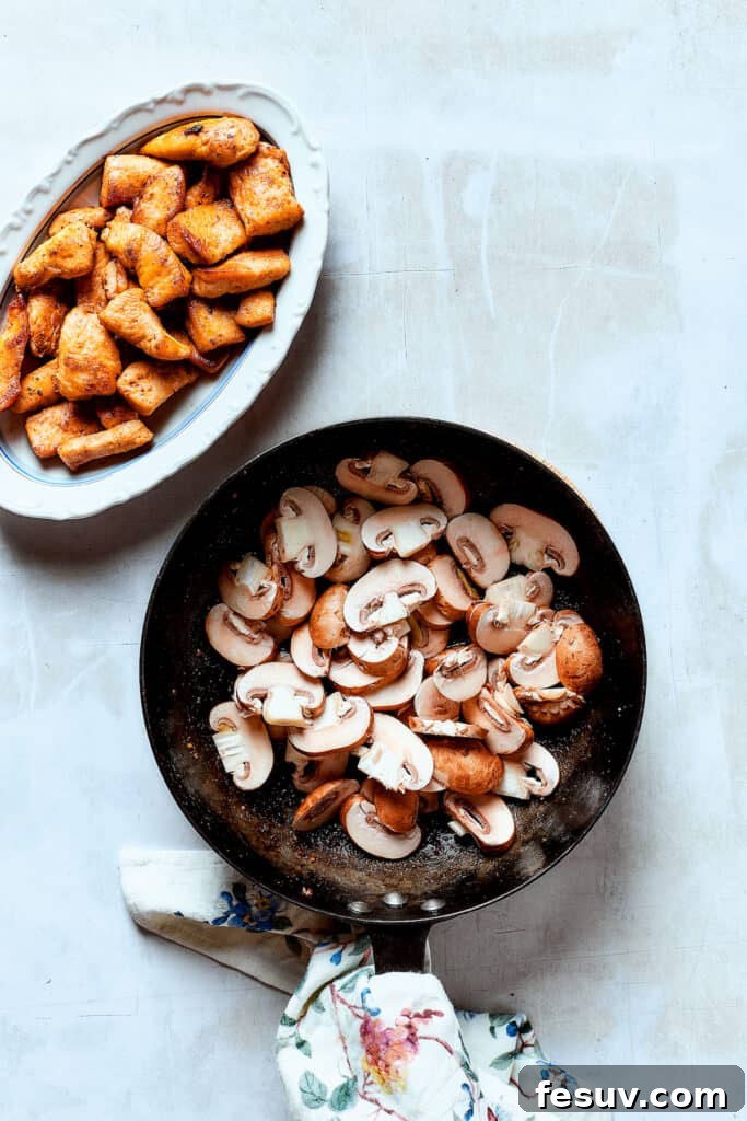 Mushrooms tenderizing in the pan. Sliced mushrooms sautéing in butter and olive oil in a skillet.