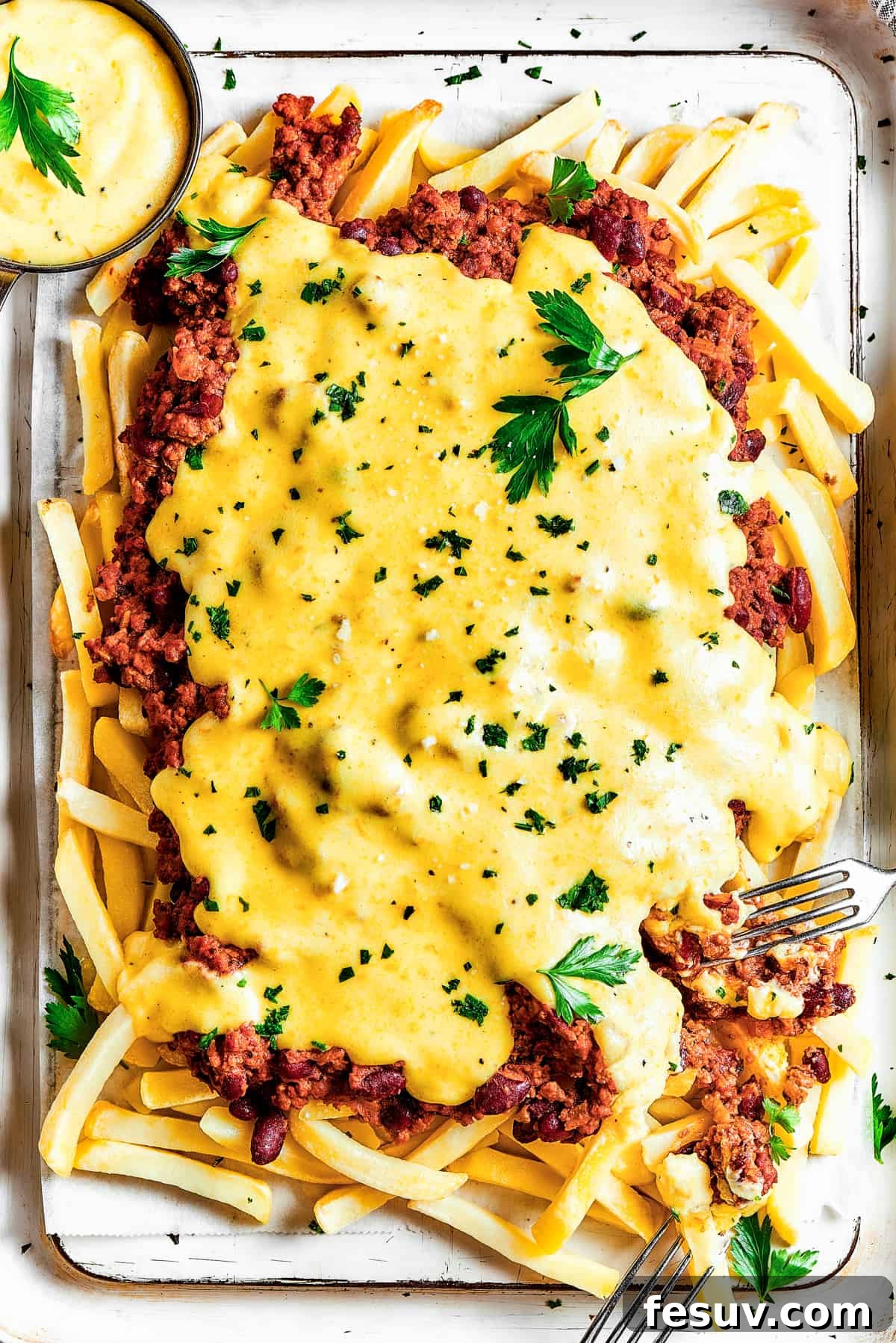 Overhead shot of chili cheese fries with dipping sauce.