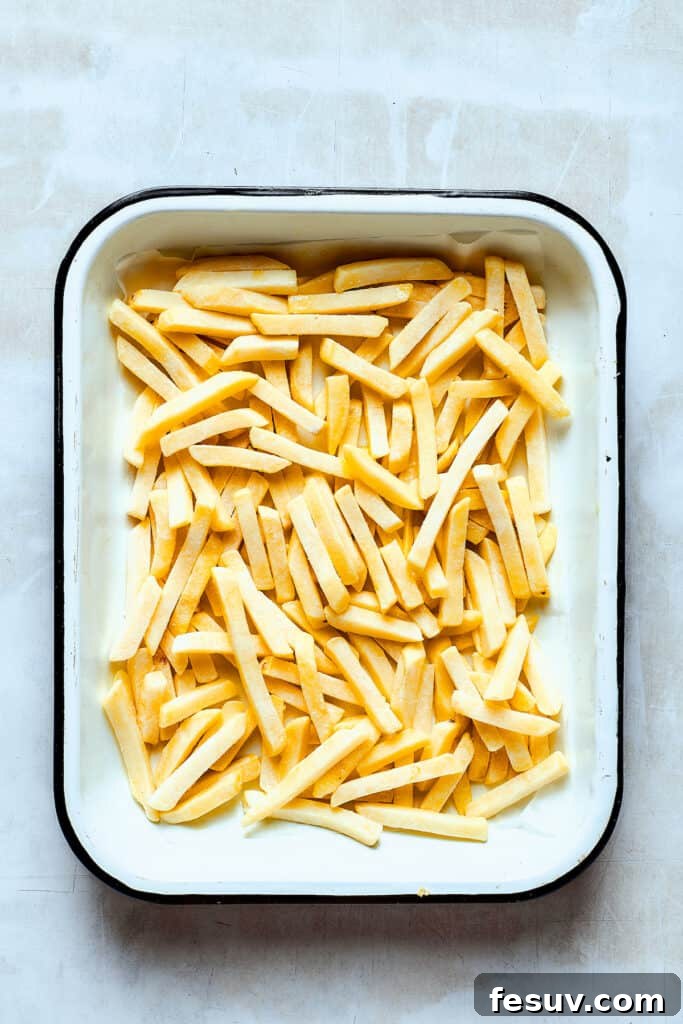 Frozen french fries on a baking sheet.