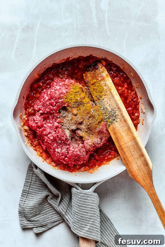 Adding beef and other ingredients to a skillet.