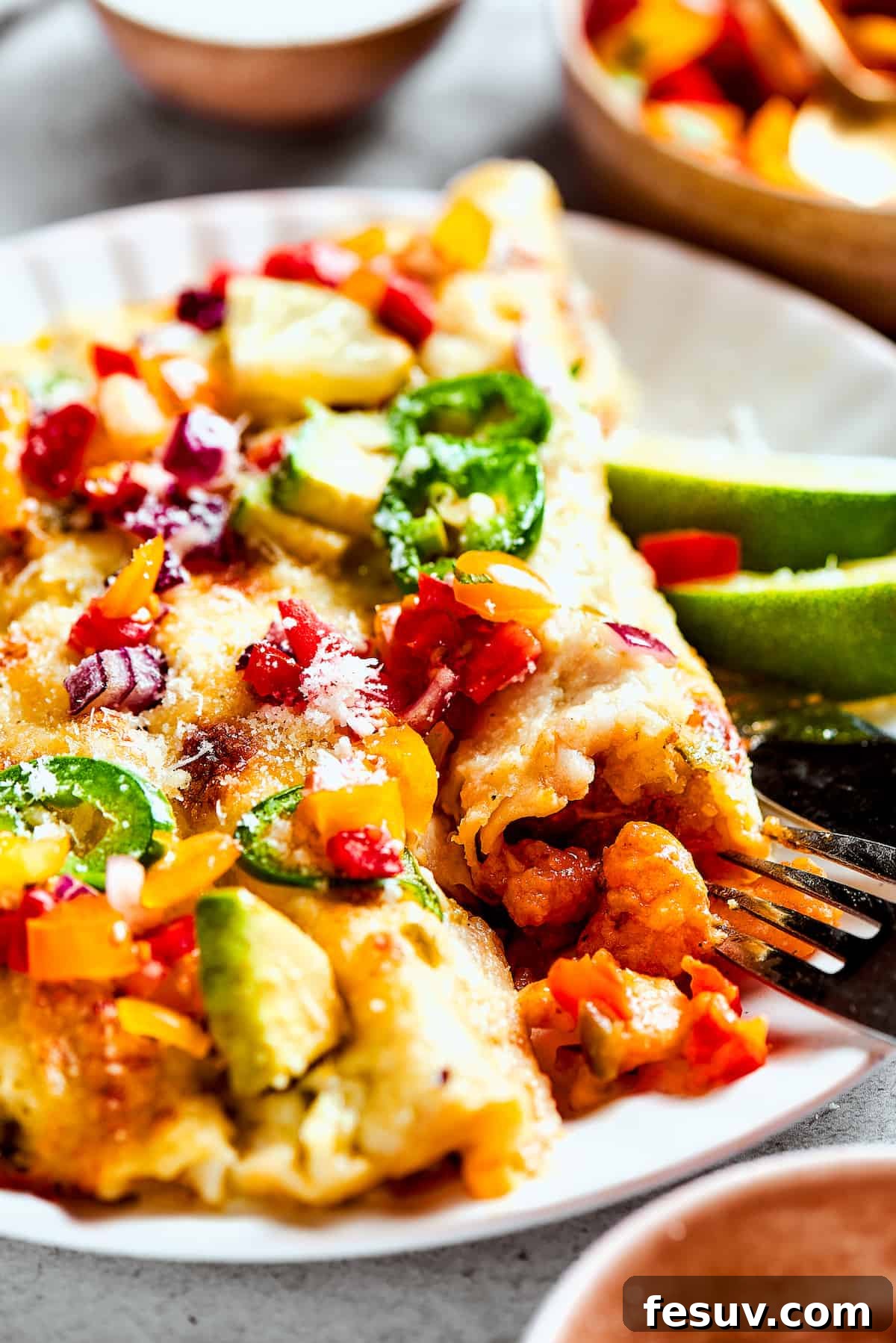 A plate of enchiladas topped with avocado and other toppings.
