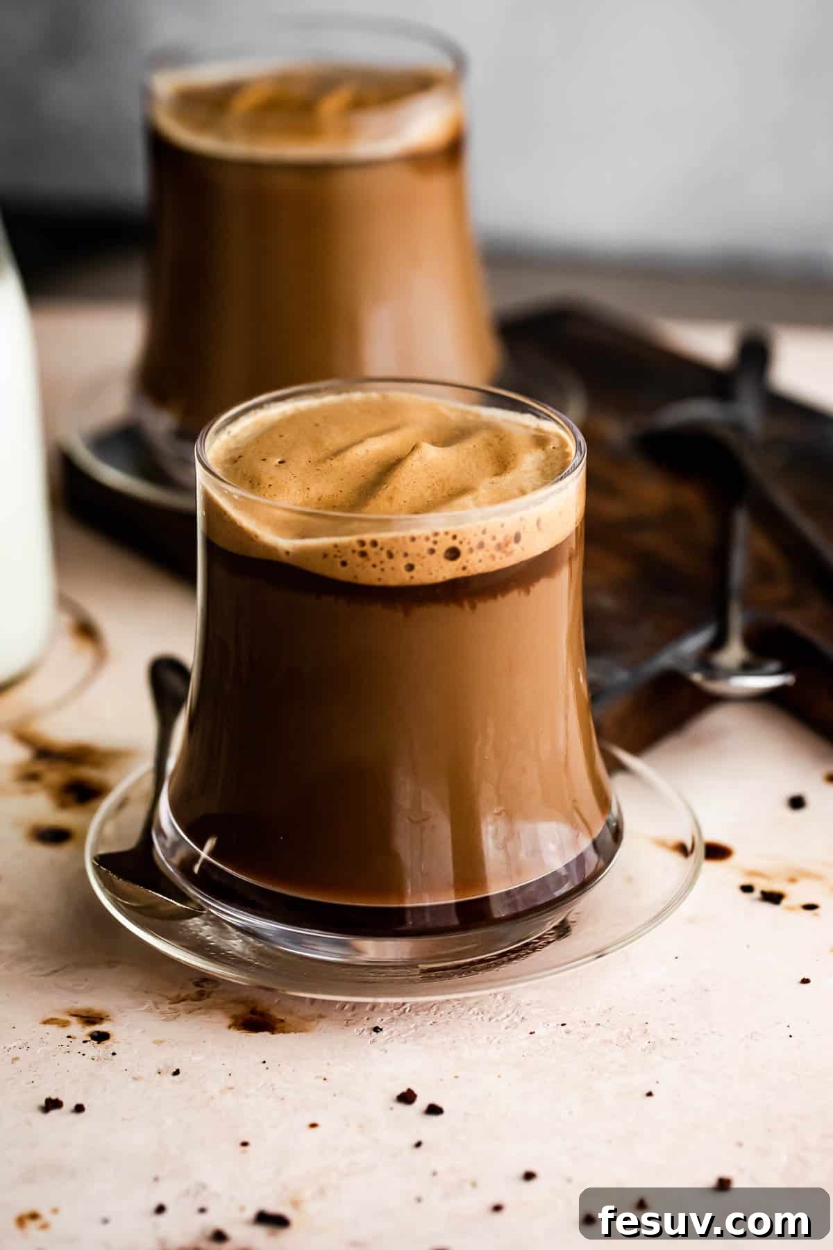 Freshly prepared Caffe Macchiatos, a simple luxury at home. Image of two glass coffee mugs filled with Caffe Macchiato.
