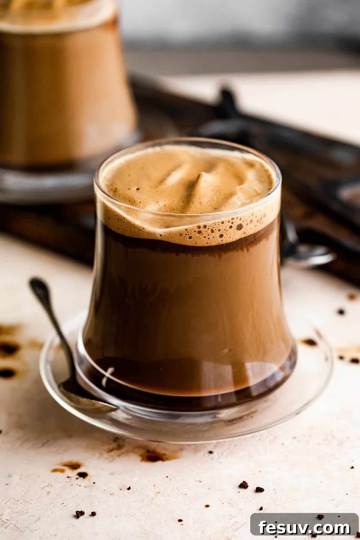 A homemade Caffe Macchiato in a clear glass mug, ready to be enjoyed. Homemade Macchiato served in a glass mug.