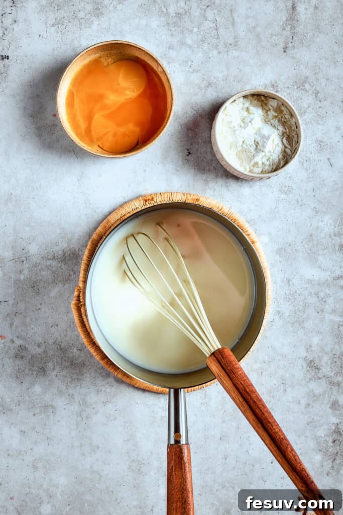 Constant whisking prevents scorching. Whisking milk and sugar together in a saucepan over medium heat.