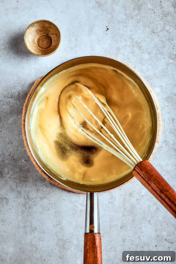 Pudding should be thick enough to coat a spoon. Thickened banana pudding mixture in a saucepan, showing its smooth, creamy consistency.
